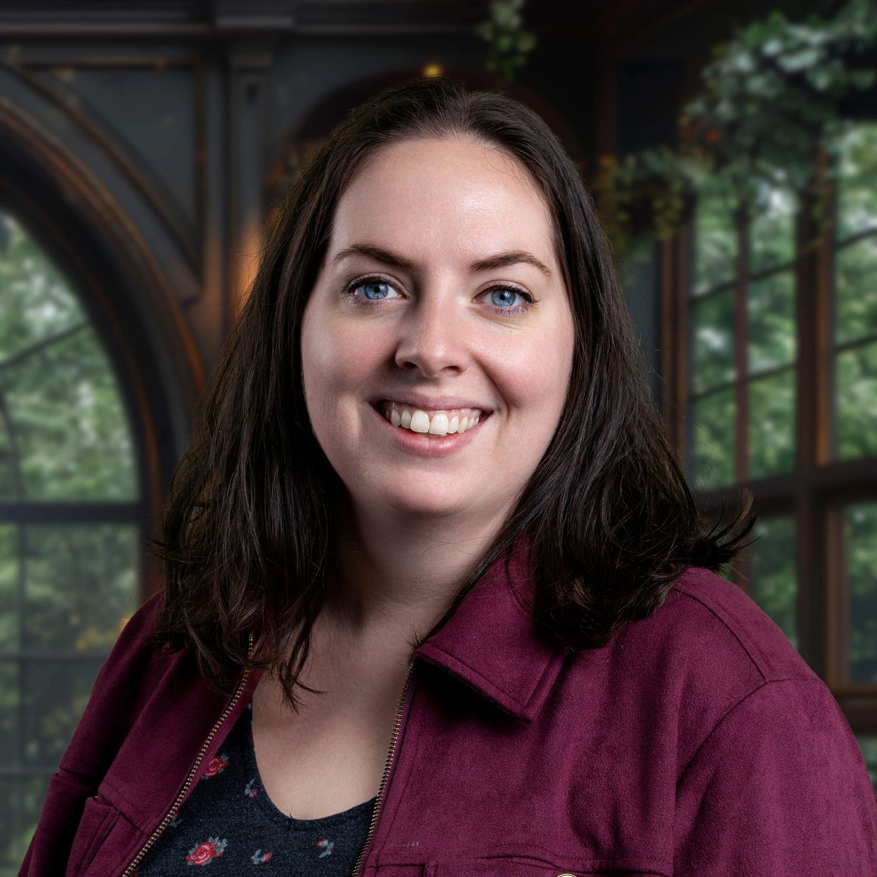 Smiling woman with blue eyes and dark hair in a cozy indoor setting.