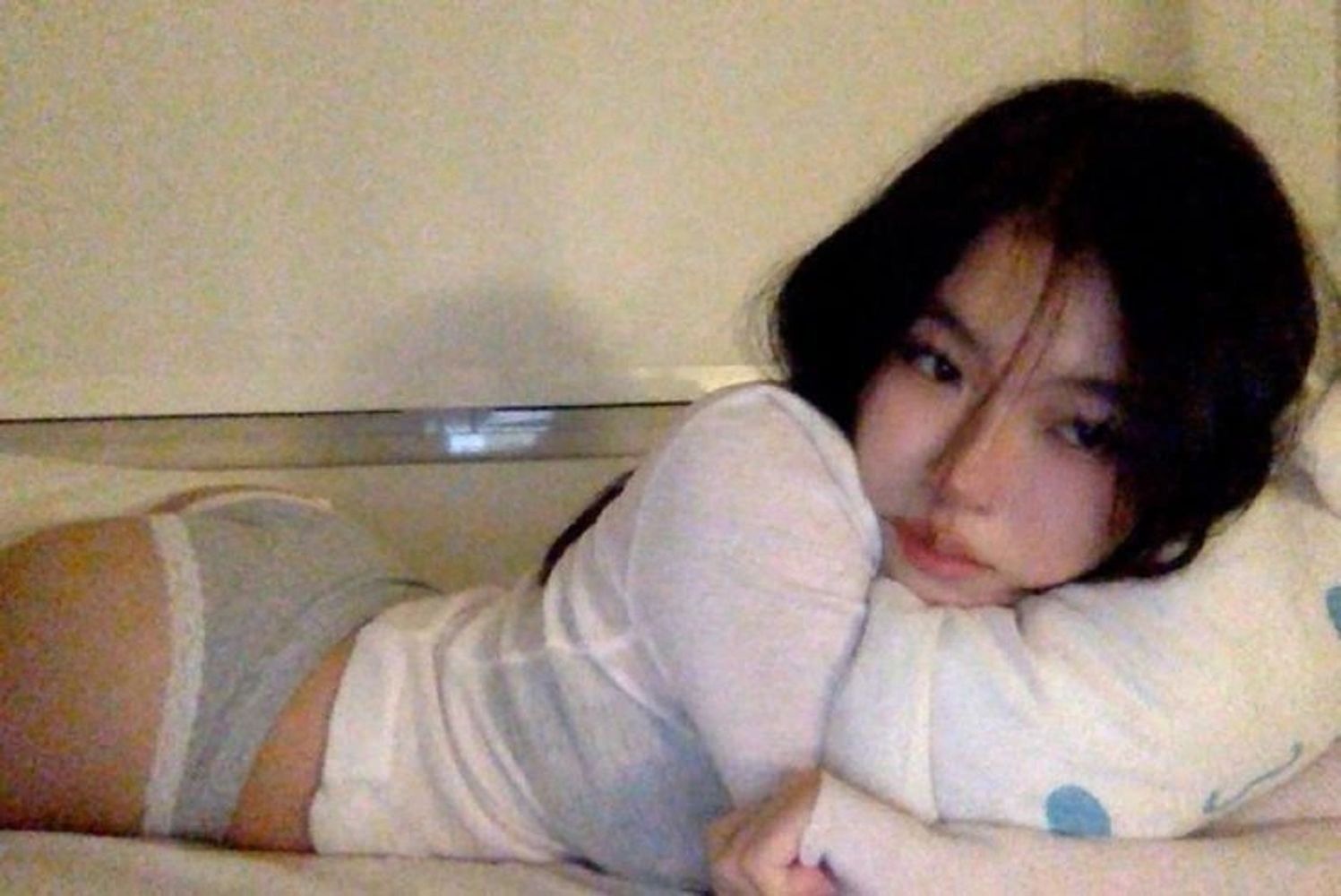 Young woman lying on her side, resting on a pillow.