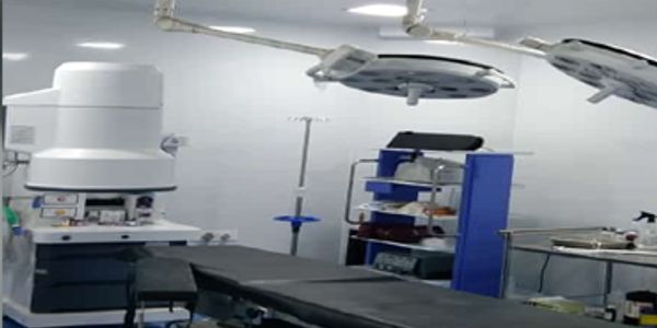 Modern medical operating room with surgical equipment and examination lights.