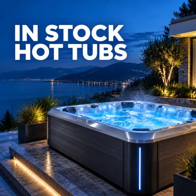 Modern hot tub lit up at night with ocean view.