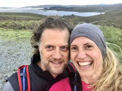 The attractive man and a woman taking a selfie on the mountain background
