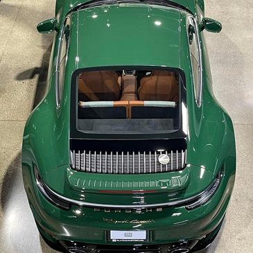 Top view of a sleek green Porsche sports car with a sunroof.
