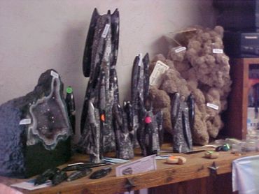 Display of various mineral and crystal formations on a wooden table.
