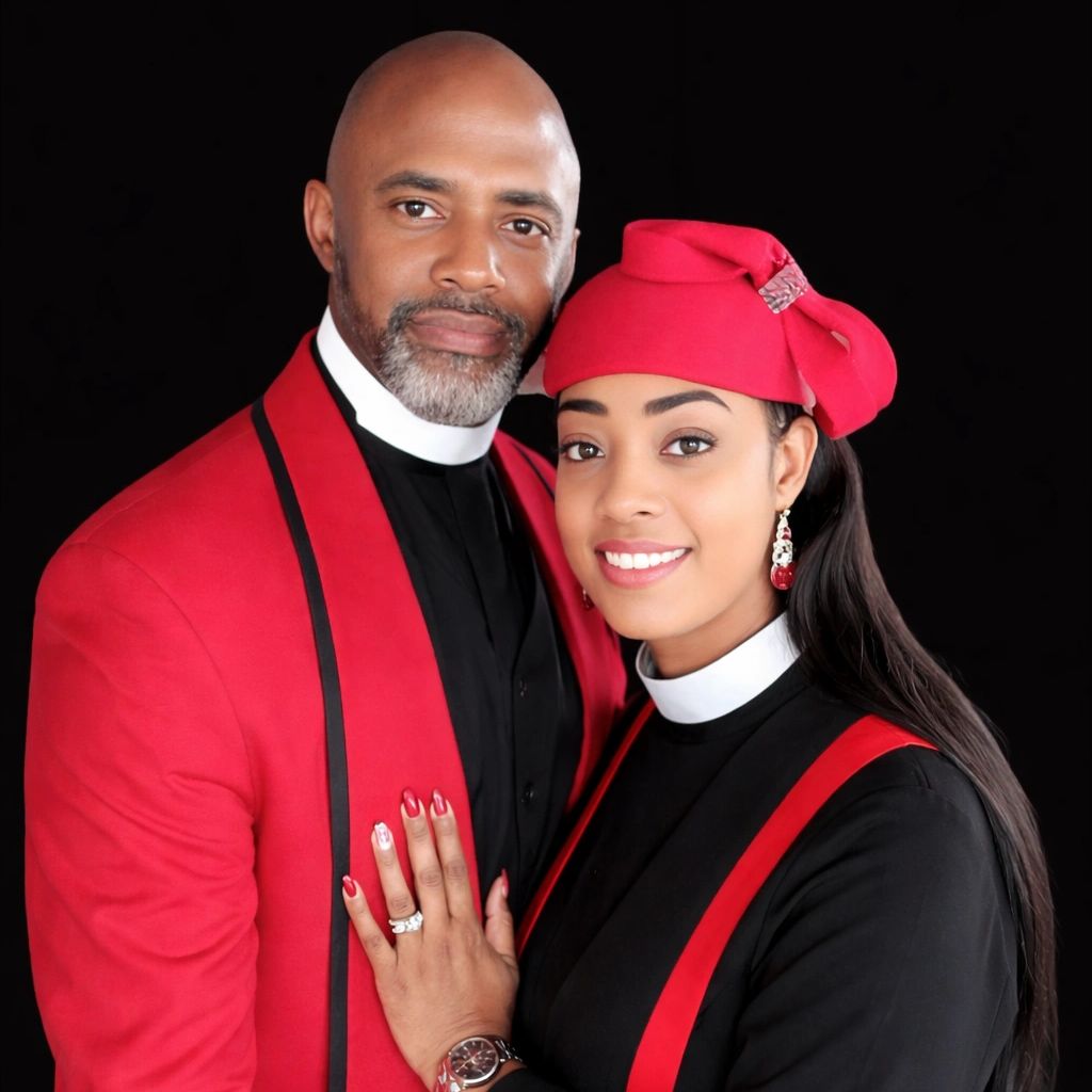 Couple dressed in matching red and black attire against a black background.