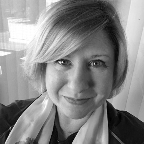 Close-up black-and-white portrait of a smiling woman with short hair.