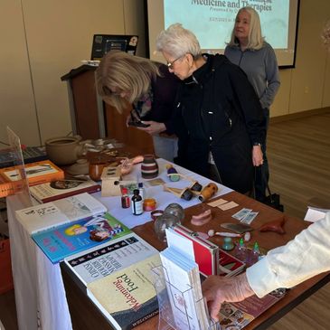 People examining various medical and wellness items on a table.