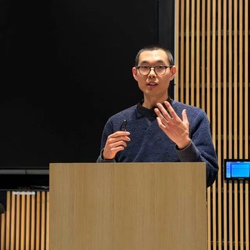 Man giving a speech behind a wooden podium.