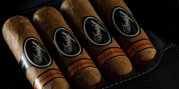 Four cigars displaying their labels inside of a cigar case