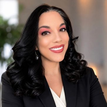 Professional woman with dark curly hair and bright smile.