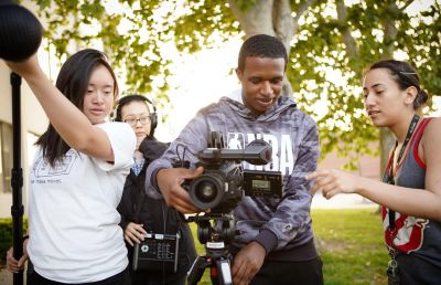 Group filming outdoors using professional camera equipment.