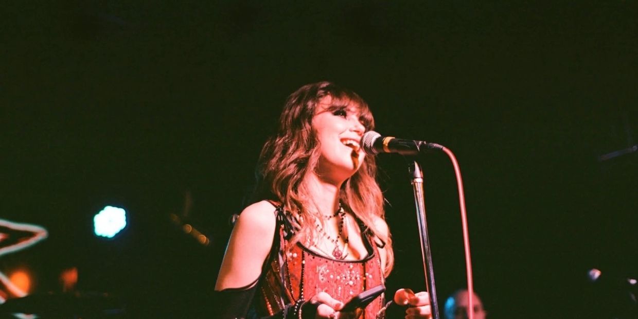 Singer performing on stage with a microphone.