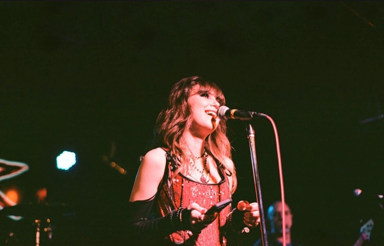 Singer performing on stage with a microphone.