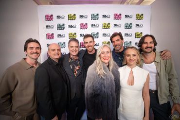 Group of eight people posing at an event.