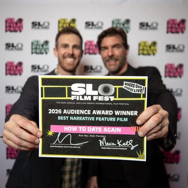 Two men holding an award certificate at SLO Film Fest.