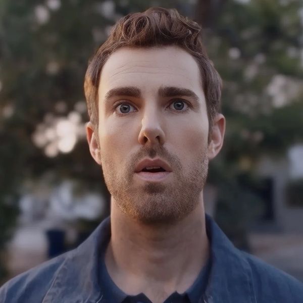 A man with a surprised expression in an outdoor setting.