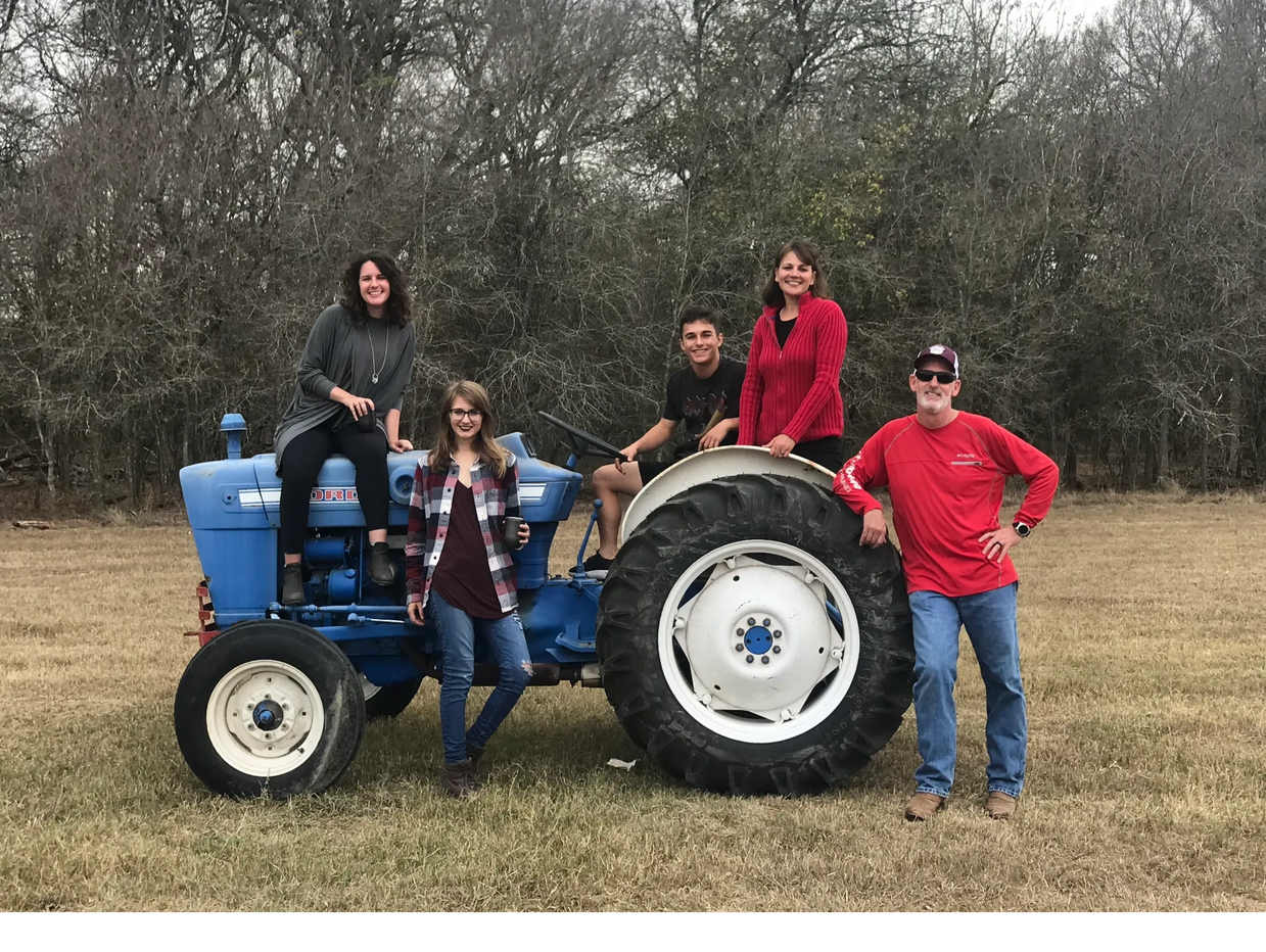 Van Horn family around a tractor at their ranch