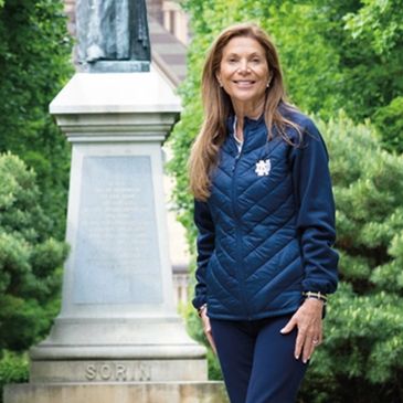 a woman in a blue jacket is smiling 