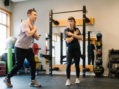 Deux personnes font des étirements en salle de sport.
