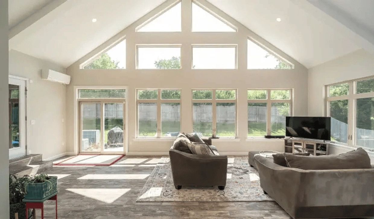 Bright living room with large windows and modern furniture.