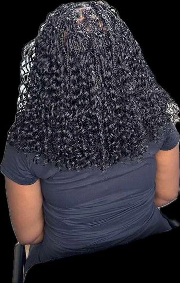 Back view of a person with curly hair styled in neat cornrows and loose curls.
