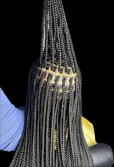 Intricately styled long box braids with neat, geometric parting.