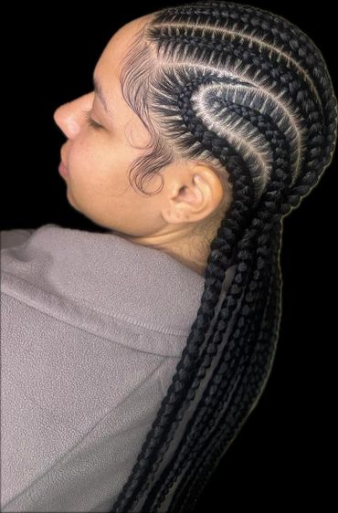 Intricately braided cornrows styled with sleek baby hairs on a person wearing a gray fleece jacket.