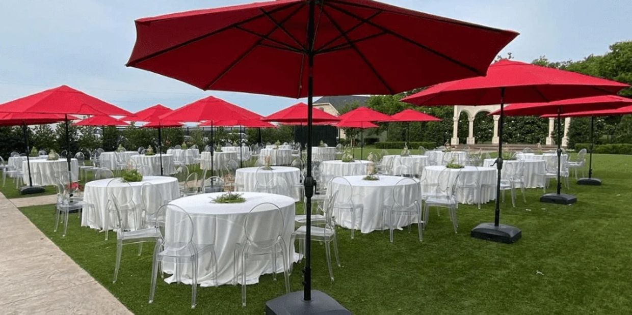 Outdoor event with ghost chair rentals and red patio umbrella rentals in Dallas, Tx.