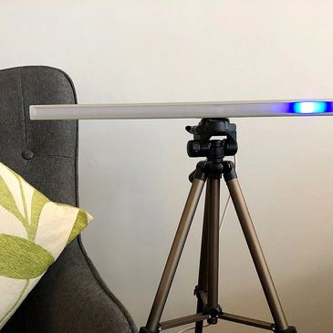Picture of an EMDR light bar next to a therapy couch with a blue light across the bar.