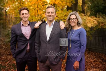 Family portrait in autumn with colorful foliage background.
