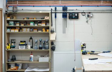 Organized workshop shelf with tools, screws, and workbench.