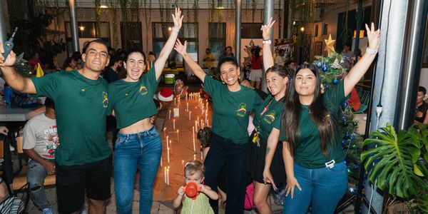 Group of friends celebrating joyfully at a festive indoor event with candles and decorations.