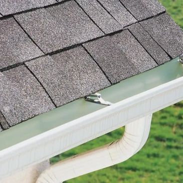 White seamless aluminum gutters and downspouts installed on residential home
