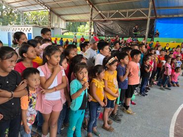 Niños reunidos en un evento bajo techo.