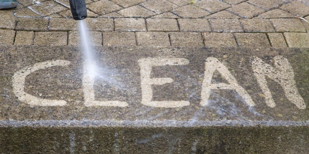 a photo a pressure washing spelling the word clean