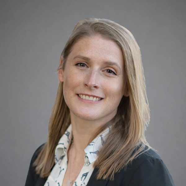 Smiling woman with blonde hair in business attire.