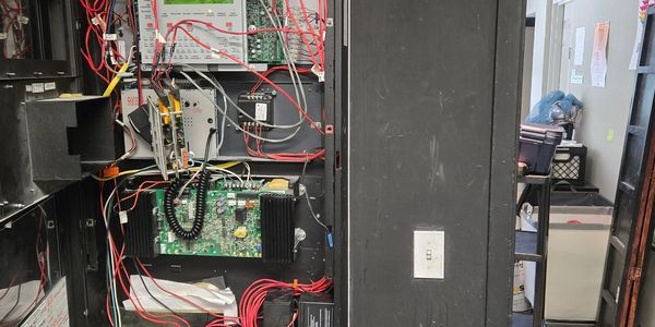Open electrical panel with wires and circuit boards.