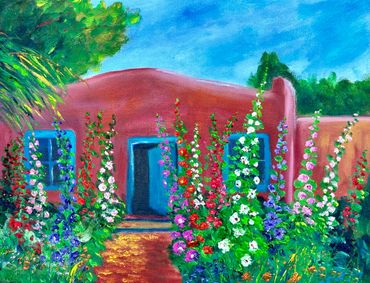 Colorful flowers bloom around a charming adobe house under a bright blue sky.