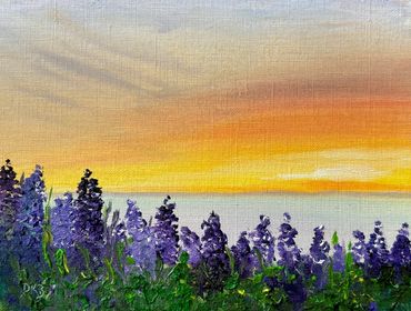 Purple flowers under a vibrant sunset sky.