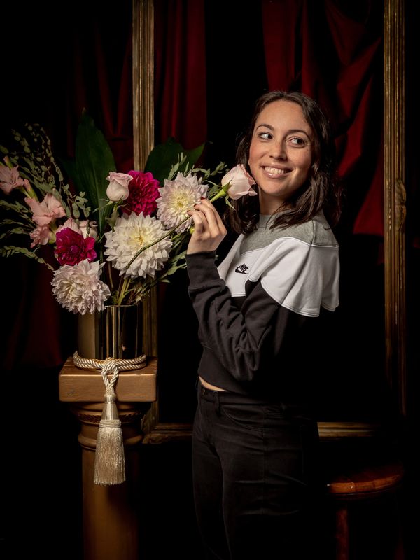 A portrait of Stefanie Tuder with a bouquet of red, white, and pink flowers