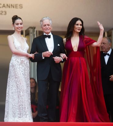 Three celebrities posing on the red carpet at Cannes.