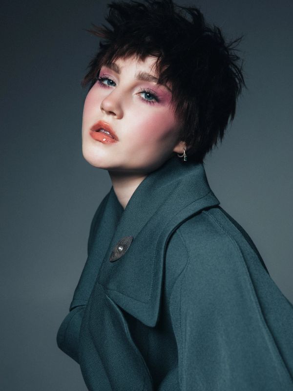 Portrait of a person with short hair and blue coat.