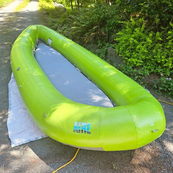 Bright green inflatable raft on a path near greenery.