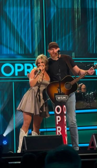 Two musicians performing together on stage at the Opry.