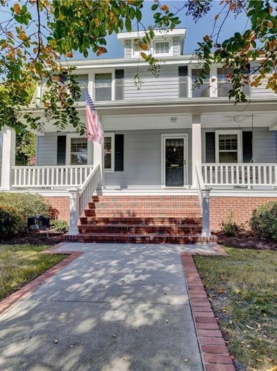 Classic American house with a spacious front porch and American flag.