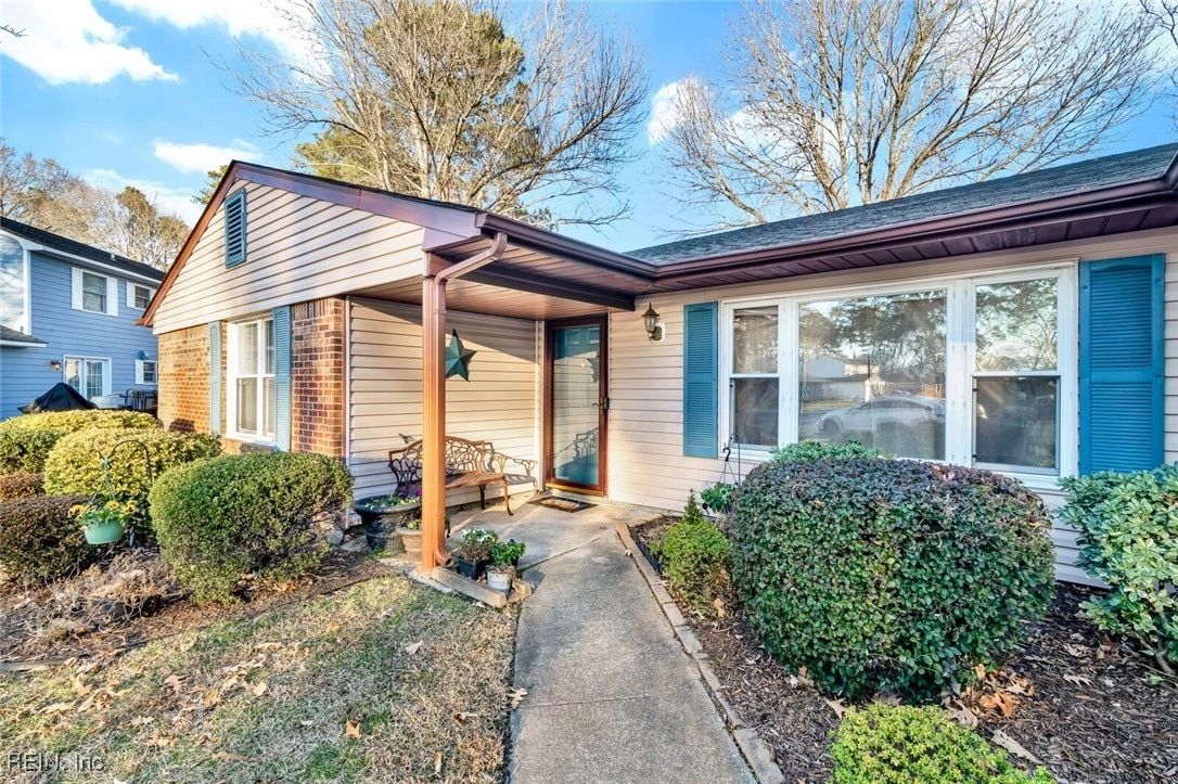 Cozy single-story house with a small covered porch and well-maintained bushes.