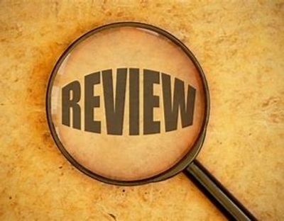 Magnifying glass highlighting the word 'REVIEW' on a textured background.