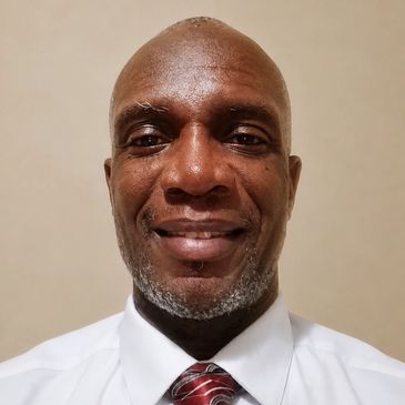 Smiling man in a white shirt and red striped tie.