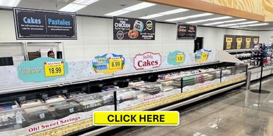 Supermarket bakery section with cakes and pastries displayed.