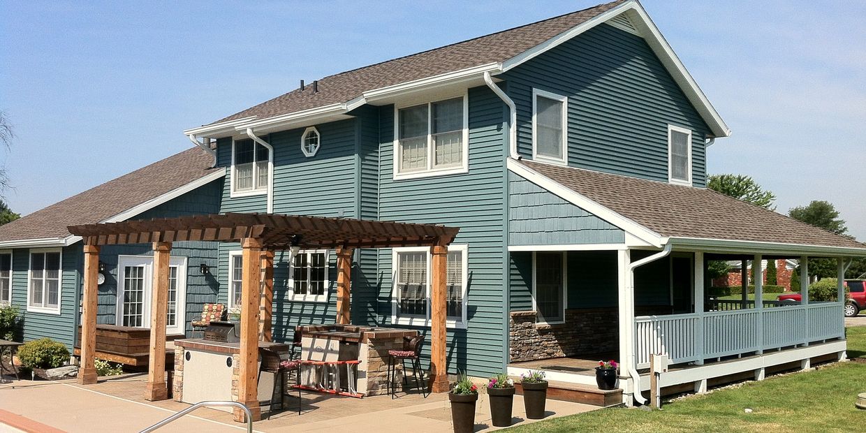 Exterior renovation - vinyl lap & shake siding, stone wainscoting, windows & doors by ES of Denver.
