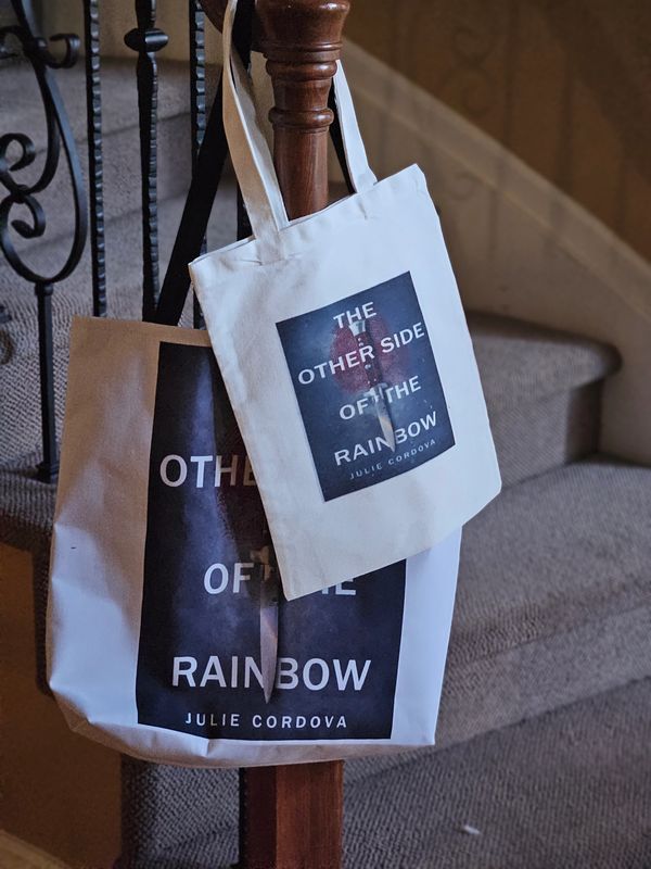 Two tote bags hanging on a wooden stair post.